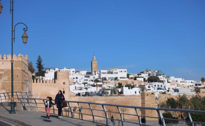 The image is for the Kasbah of Oudayas in Rabat. The image also shows a lady walking with her daughter in the back side of the Kasbah during our Morocco travel package - Morocco holiday - Morocco tour package - Morocco trip package - 10 day Morocco travel package from Casablanca