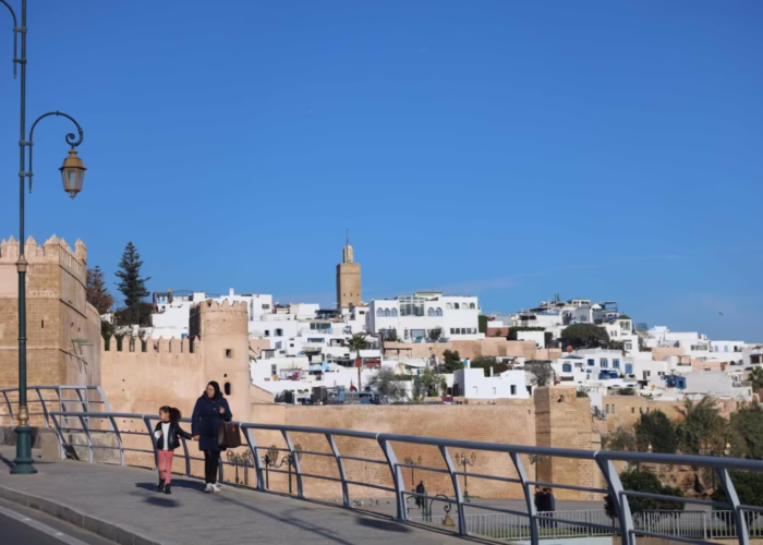 The image is for the Kasbah of Oudayas in Rabat. The image also shows a lady walking with her daughter in the back side of the Kasbah during our Morocco travel package - Morocco holiday - Morocco tour package - Morocco trip package - 10 day Morocco travel package from Casablanca
