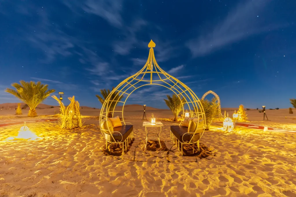 Luxury desert camp in Merzouga lit up at night
