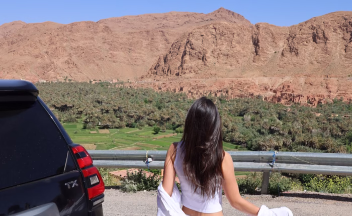 Moroccan travel image of a woman enjoying a panoramic view of Todra Valley during our 4 Morocco Desert tour from Marrakech to Fes. Best Morocco vacation package