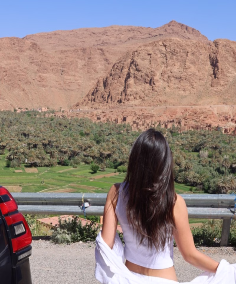 Moroccan travel image of a woman enjoying a panoramic view of Todra Valley during our 4 Morocco Desert tour from Marrakech to Fes. Best Morocco vacation package